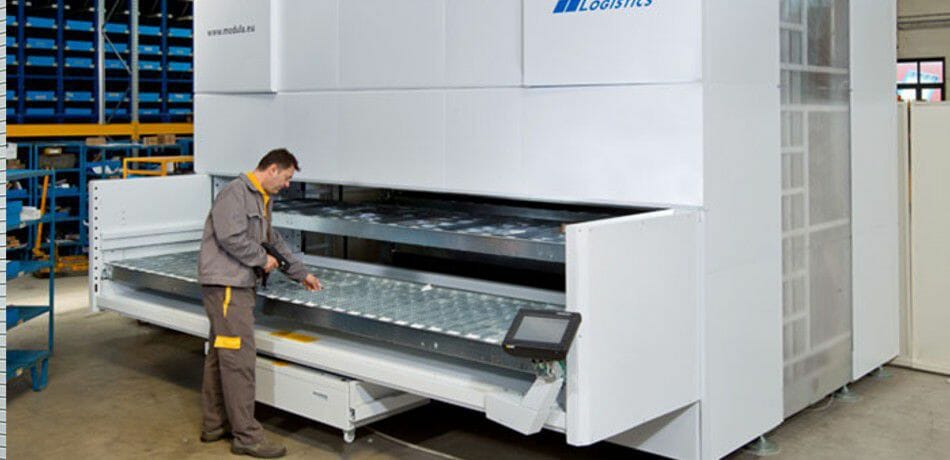 A man is selecting an item from the vertical lift module